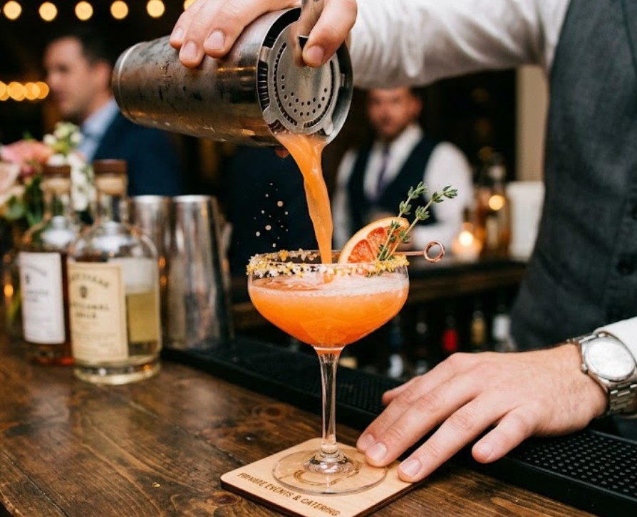 Bartender pouring a craft cocktail at a private Houston event